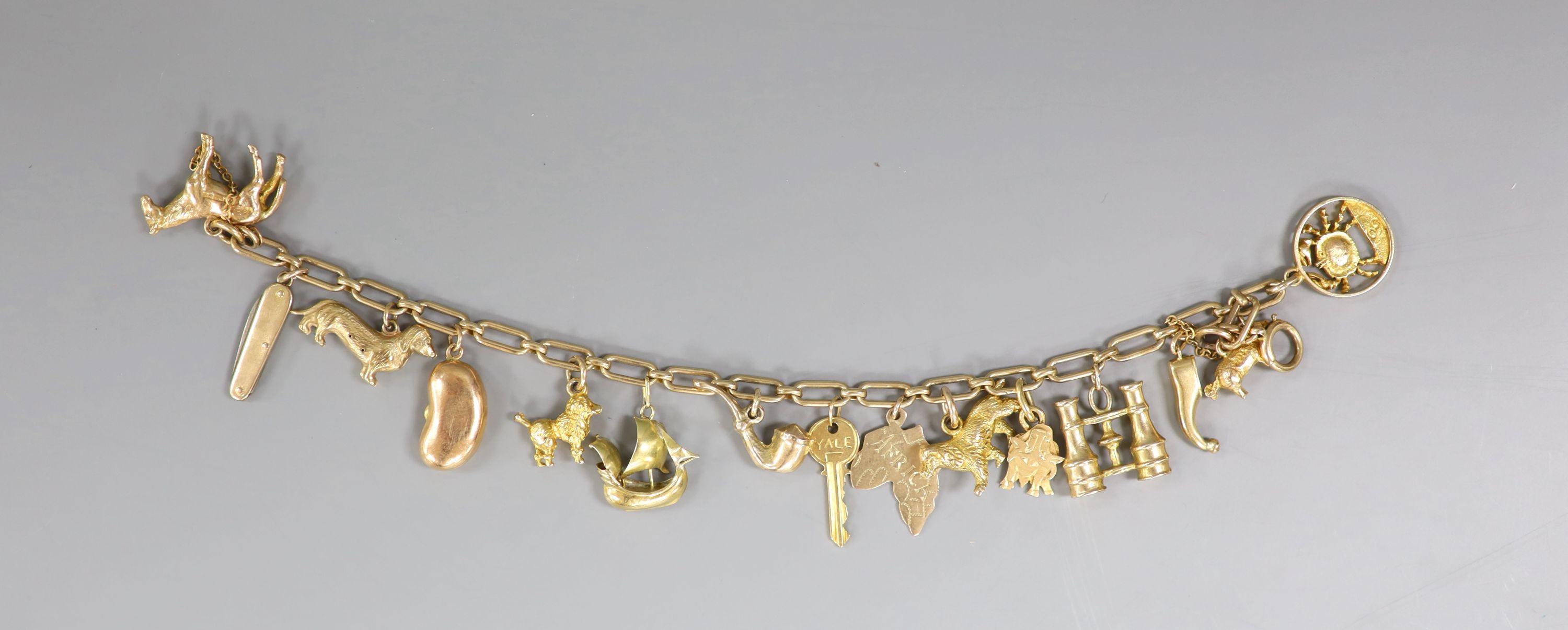 A 9ct oval link charm bracelet, hung with assorted mainly 9ct gold charms, gross weight 31.5 grams.